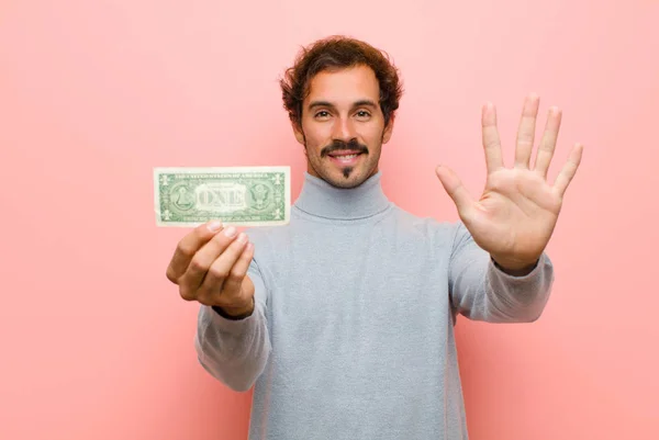 Pembe Düz Duvarda Dolar Banknotları Olan Genç Yakışıklı Bir Adam — Stok fotoğraf