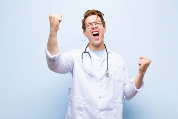 Νεαρός Κοκκινομάλλης Γιατρός Που Φωνάζει Θριαμβευτικά Δείχνοντας Ενθουσιασμένος Χαρούμενος Και — Φωτογραφία Αρχείου