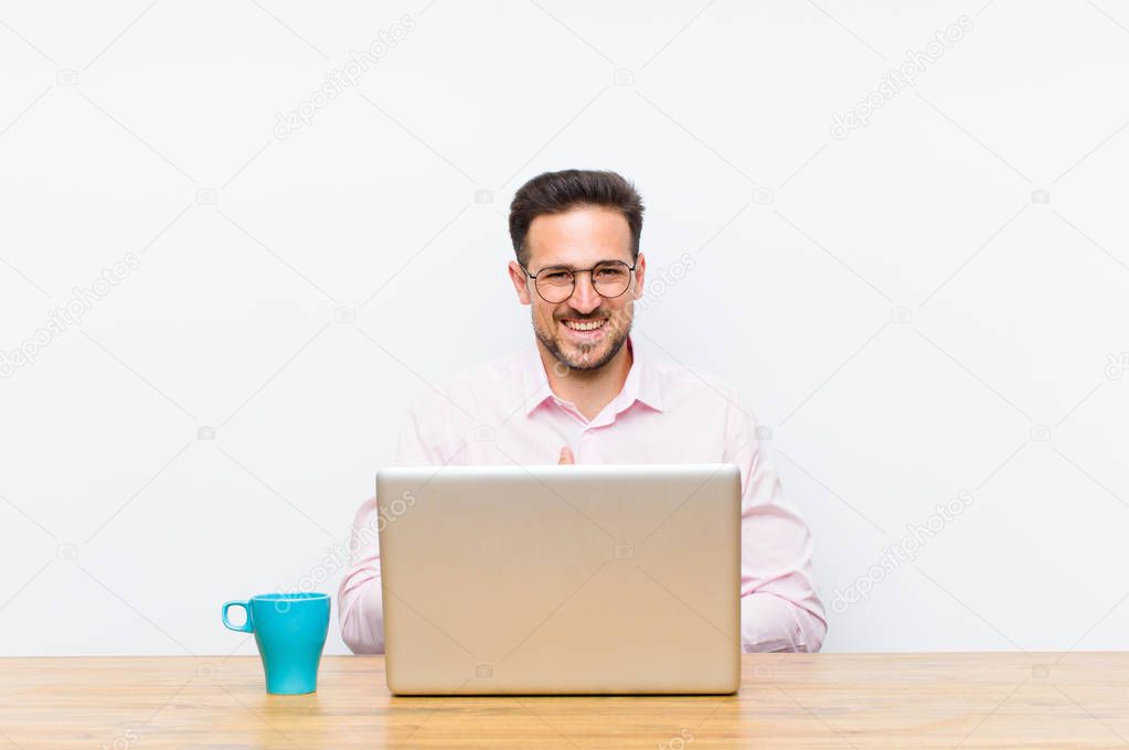 young handsome businessman laughing out loud at some hilarious joke, feeling happy and cheerful, having fun