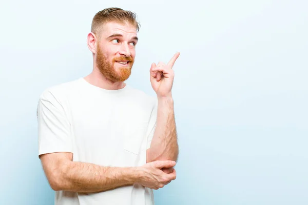 Junger Mann Mit Rotem Kopf Lächelt Glücklich Und Schaut Seitwärts — Stockfoto