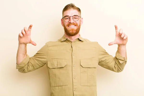 年轻的红头发男人用双手塑造或勾勒出自己的笑容 在米色的背景下显得积极快乐 — 图库照片