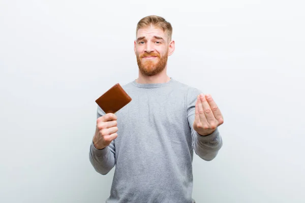 白い背景に財布を持つ若い赤い頭の男 — ストック写真