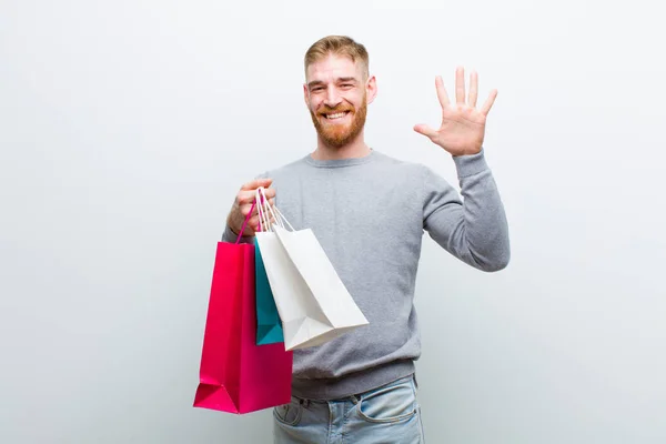 Joven Cabeza Roja Hombre Con Bolsas Compras Sobre Fondo Blanco —  Fotos de Stock