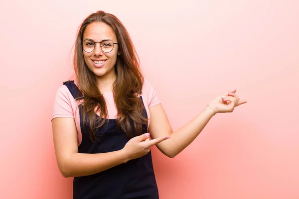 若い女性は ピンクの背景を背景にコピースペースの概念やアイデアを指して 屈託のない満足感 — ストック写真