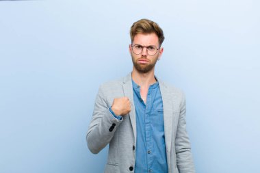 Genç işadamı kafası karışmış, kafası karışmış ve güvensiz hissediyor. Kendini merak edip bana mı soruyor? mavi arkaplan