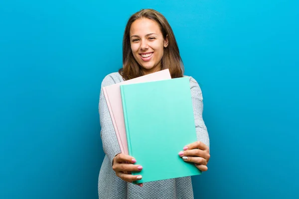 Ung kvinna med en anteckningsbok mot blå bakgrund — Stockfoto