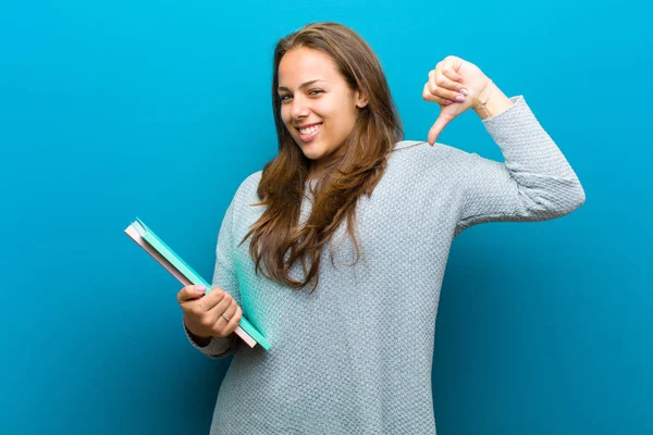 Jeune femme avec un cahier sur fond bleu — Photo