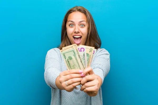 Mujer joven con cuentas contra fondo azul — Foto de Stock