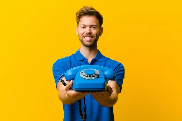 Junger Mann Mit Telefon Vor Orangefarbenem Hintergrund — Stockfoto