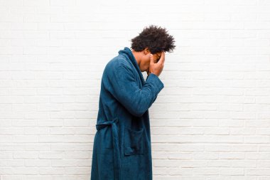 Genç siyahi bir adam pijama giyiyordu. Önlüğü, gözleri ve elleri üzgündü. Hüzünlü bir bakışla ağlıyordu.