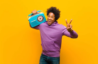 Turuncu B 'ye karşı klasik radyosu olan genç Afro-Amerikan bir adam.