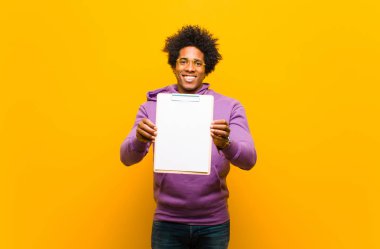 Genç Afrikalı Amerikalı adam turuncu arka plana karşı