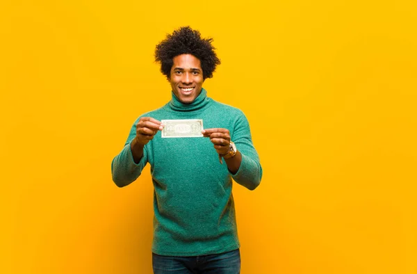 오렌지를 반대하는 달러 지폐를 가진 젊은 아프리카 계 미국인 남자 — 스톡 사진