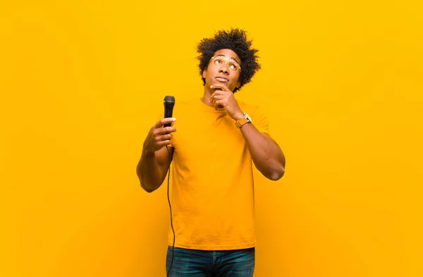 Giovane uomo afroamericano con un microfono che canta contro o — Foto Stock