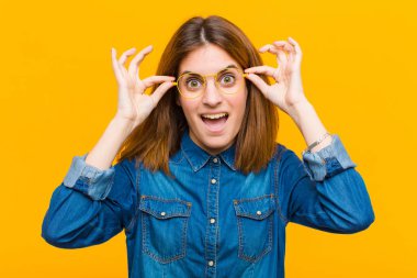 Genç, güzel bir kadın şok olmuş, şaşırmış ve şaşırmış hissediyor. Sarı arka planda hayrete düşmüş, inançsız bir bakış atıyor.