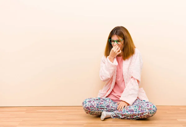 Mujer Joven Usando Pijamas Sentada Casa Sintiéndose Disgustada Sosteniendo Nariz —  Fotos de Stock