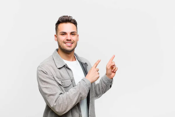 Молодий Іспаномовний Чоловік Посміхається Щасливо Вказує Бік Вгору Обома Руками — стокове фото
