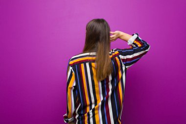 genç güzel kadın düşünme veya şüphe, kafa kaşıma, şaşkın ve karışık duygu, mor arka plan karşı arka veya arka görüş