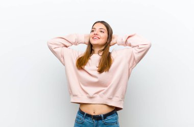 Genç ve güzel bir kadın gülümsüyor ve rahatlıyor, tatmin oluyor ve kaygısız, pozitif gülüyor ve beyaz arka plana karşı ürperiyor.