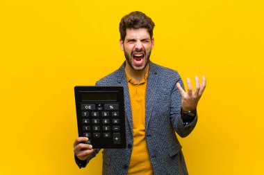 Turuncu arka planda hesap makinesi olan genç yakışıklı bir adam.