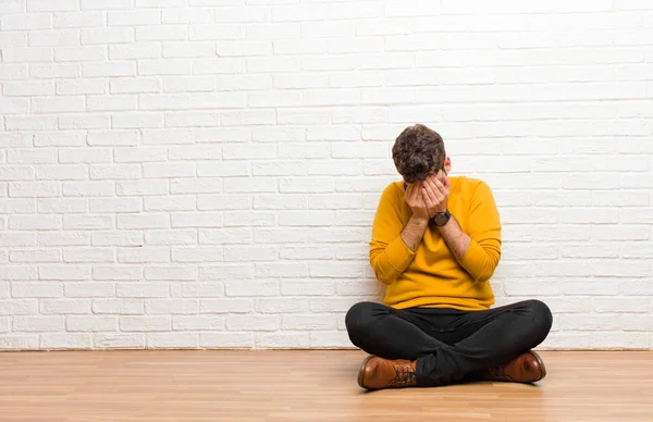 Junger Gutaussehender Mann Sitzt Auf Dem Fußboden Vor Einer Ziegelwand — Stockfoto