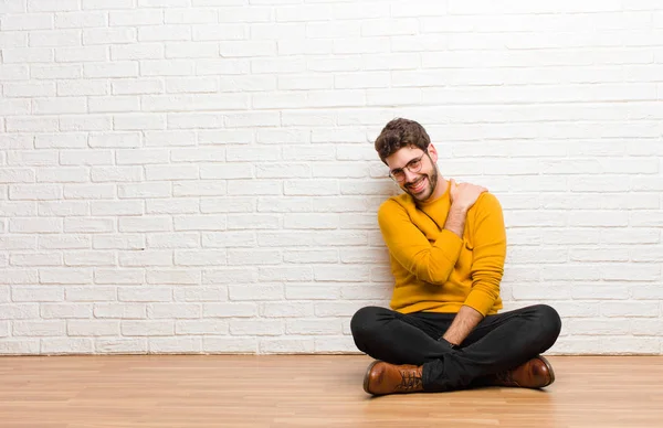 Joven Hombre Guapo Sentado Suelo Casa Contra Textura Pared Ladrillo —  Fotos de Stock