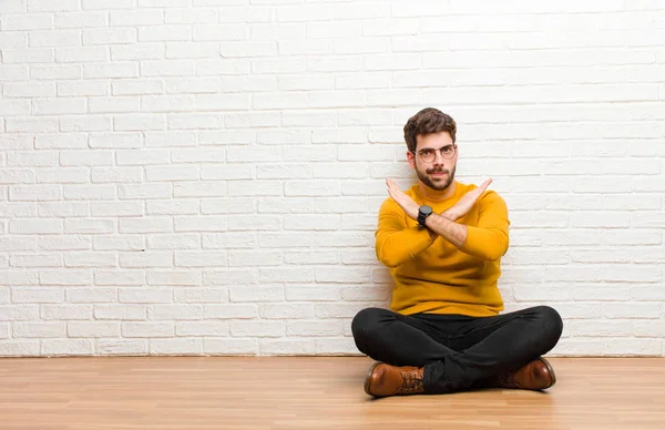 Junger Gutaussehender Mann Sitzt Auf Dem Fußboden Vor Einer Ziegelwand — Stockfoto