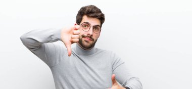 Genç yönetici kafası karışık, bilgisiz ve kararsız hissediyor, iyi ve kötü seçenekleri tartıyor ya da beyaz duvara karşı seçenekleri değerlendiriyor.