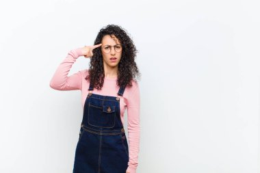 Genç, güzel bir kadın kafası karışık ve şaşkın hissediyor. Deli, deli ya da beyaz duvara karşı aklını kaçırmış olduğunu gösteriyor.