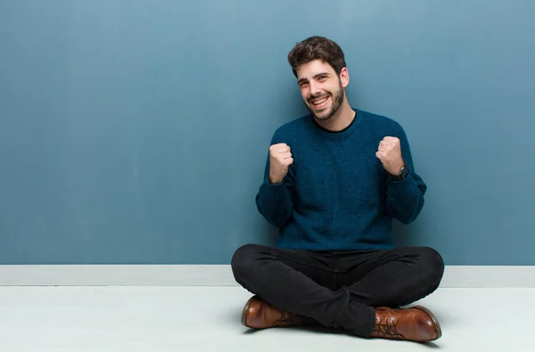 Joven Hombre Guapo Sentado Suelo Sintiéndose Sorprendido Emocionado Feliz Riendo —  Fotos de Stock