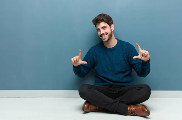 Joven Hombre Guapo Sentado Suelo Enmarcando Esbozando Propia Sonrisa Con —  Fotos de Stock