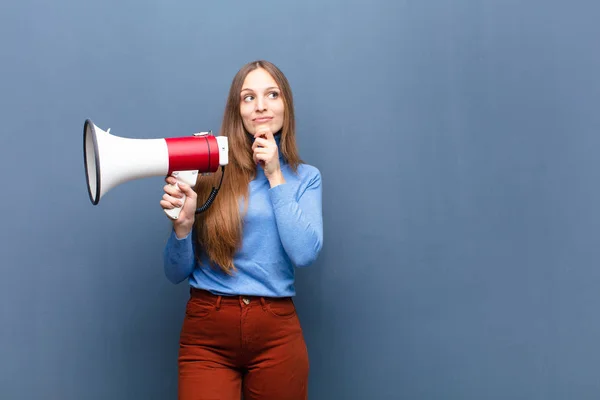 Jonge Mooie Vrouw Met Een Megafoon Tegen Blauwe Muur Met — Stockfoto