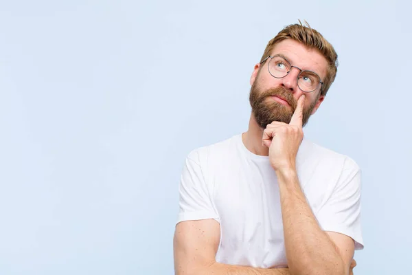 Ung Blond Vuxen Man Med Koncentrerad Look Undrar Med Ett — Stockfoto