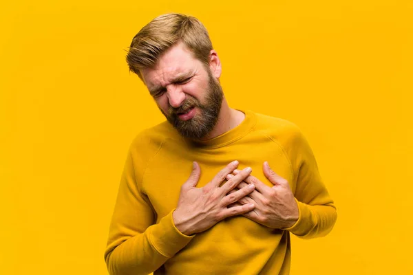 Jonge Blonde Man Kijkt Verdrietig Gekwetst Gebroken Hart Houdt Beide — Stockfoto