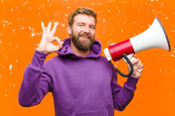 Jovem Loiro Com Megafone Usando Capuz Roxo Contra Parede Laranja — Fotografia de Stock