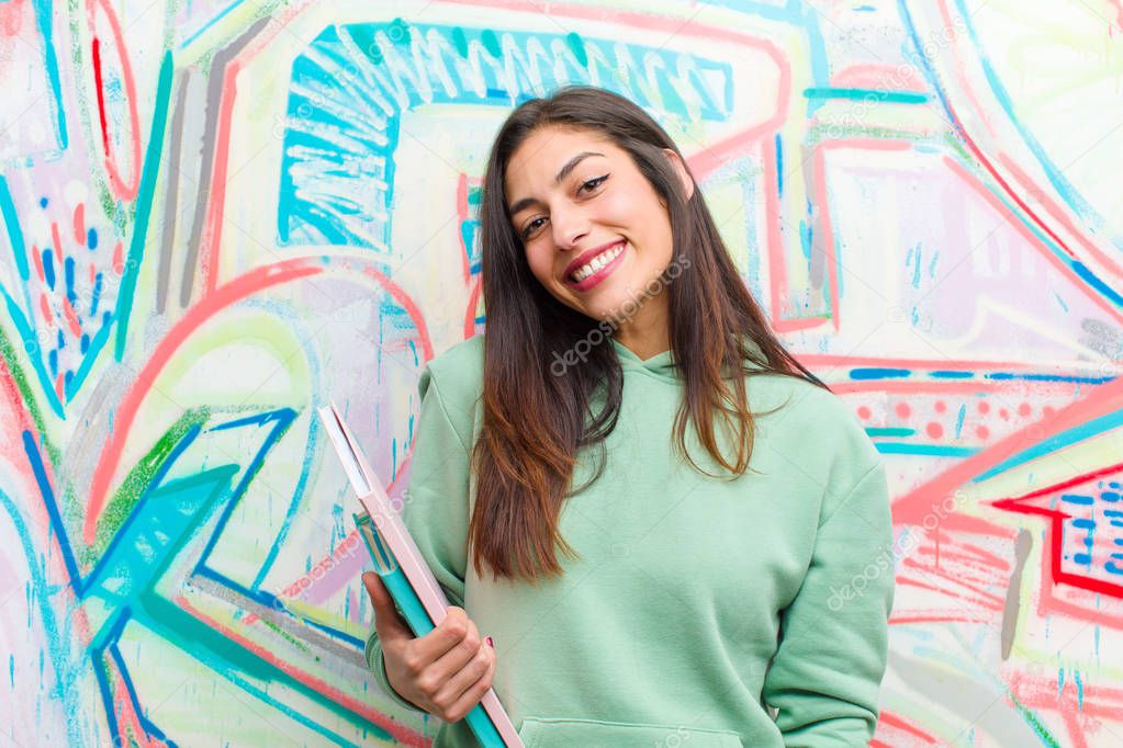 young pretty woman against graffiti wall