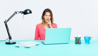 Dizüstü bilgisayarla çalışan genç, güzel bir kadın. Şaşırmış, gergin, endişeli ya da korkmuş bakışları olan bir kadın.