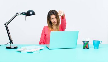 Genç ve güzel bir kadın dizüstü bilgisayarla çalışıyor kızgın, sinirli, hayal kırıklığına uğramış ya da hoşnutsuz, ciddi bir bakışla reddediyor.