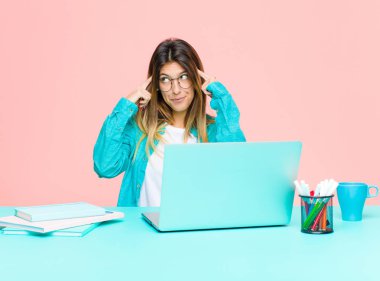 Genç ve güzel bir kadın dizüstü bilgisayarla çalışıyor. Yoğunlaşmış ve bir fikir üzerinde kafa yoruyor. Bir soruna ya da soruna çözüm bulmayı hayal ediyor.