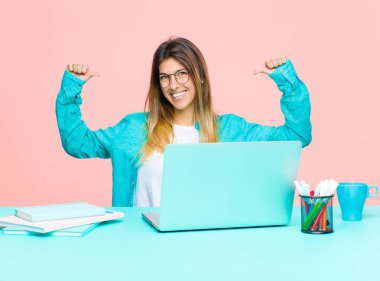 Dizüstü bilgisayarla çalışan genç ve güzel bir kadın gururlu, kibirli ve kendinden emin, tatmin olmuş ve başarılı görünüyor, kendini işaret ediyor.