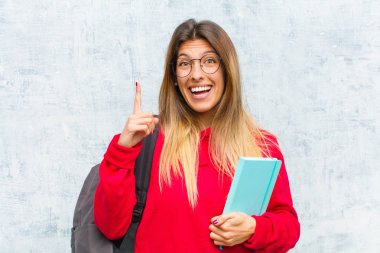 Genç ve güzel bir öğrenci bir fikri fark ettikten sonra mutlu ve heyecanlı bir dahi gibi hissediyor, neşeli bir şekilde parmağını kaldırıyor, eureka!