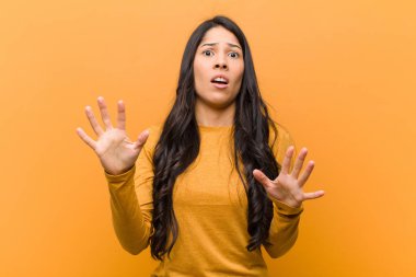 Genç, güzel İspanyol bir kadın sersemlemiş ve korkmuş hissediyor. Korkutucu bir şeyden korkuyor. Elleri açık ve kahverengi duvardan uzak durun diyor.