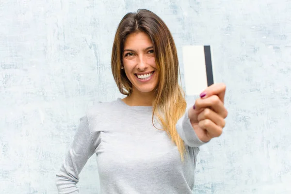 Ung Vacker Kvinna Med Ett Kreditkort Mot Grunge Vägg — Stockfoto