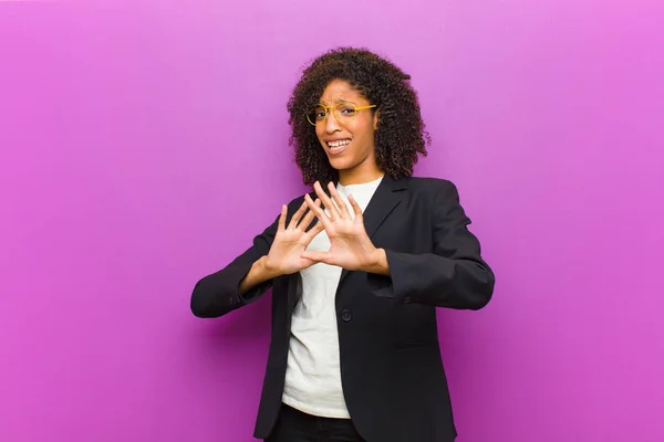 young black business woman feeling terrified, backing off and screaming in horror and panic, reacting to a nightmare