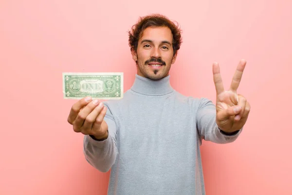Pembe Düz Duvarda Dolar Banknotları Olan Genç Yakışıklı Bir Adam — Stok fotoğraf