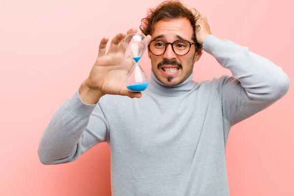 Joven Hombre Guapo Con Temporizador Reloj Arena Contra Pared Plana —  Fotos de Stock