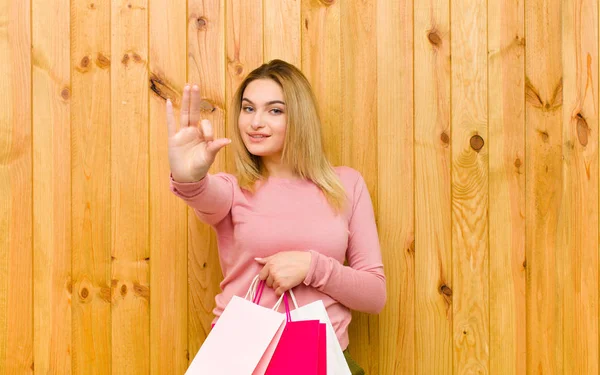 Jovem Mulher Loira Bonita Com Sacos Compras Contra Parede Madeira — Fotografia de Stock