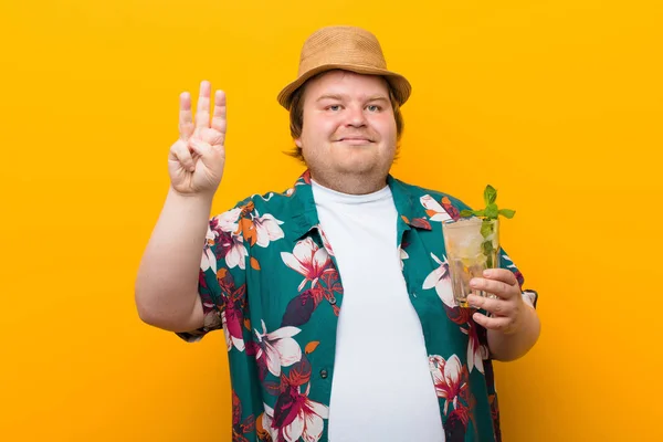 young big size man with a mojito drink against flat wall