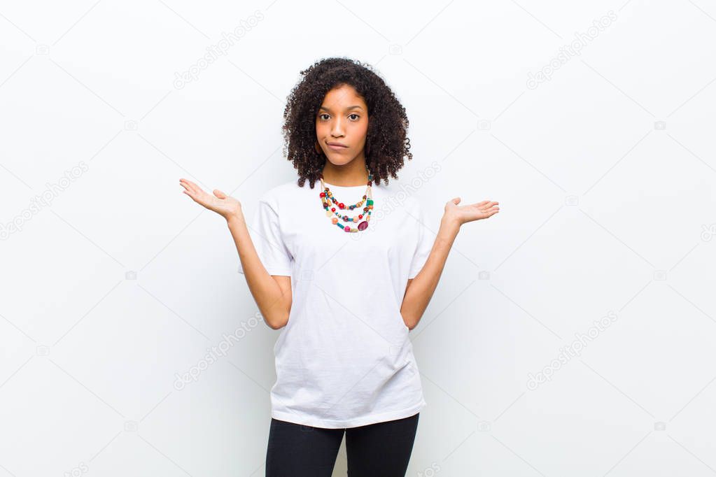 young cool african american woman feeling puzzled and confused, doubting, weighting or choosing different options with funny expression