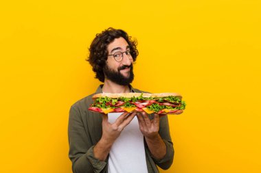 young crazy bearded man with a giant sandwich. clipart